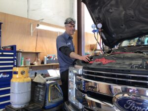 Dylan, one of the mechanics at Scofield Automotive repair in Roseburg and Green, OR working on a cars a/c