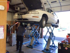 Rich, a mechanic at Scofield Automotive repair in Roseburg and Green OR inspecting a car on a lift